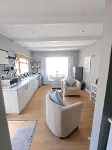Una sala de estar con un sofá y una cocina. en Mons Pes in Lakeside, en Ciudad del Cabo