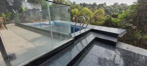 una piscina con parete in vetro su una casa di Rustic Kraft ad Alto Porvorim