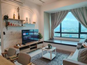 un salon avec une télévision et une grande fenêtre dans l'établissement Sunway Greenfield Residence with Amazing Pool Facilities, à Petaling Jaya