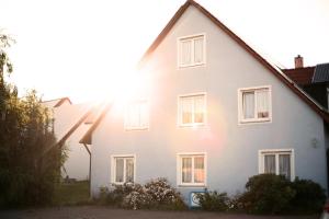 een wit huis met de zon erop bij Ferienhaus Gleissbuck in Schönbronn