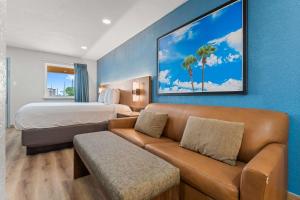 een hotelkamer met een bank en een bed bij Econo Lodge Inn & Suites Sealy in Sealy