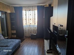 una stanza con una camera da letto con un letto e una finestra di Garsonieră cu toate facilitățile, foarte aproape de stația de tren Suceava a Suceava