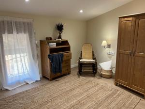 a room with a dresser and a chair and a window at Can Sole Rural in Granja de Escarpe +27 photos