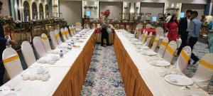 a group of long tables with plates on them at Gopalas Residency Bhumi World Bhiwandi in Bhiwandi