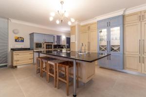 una gran cocina con armarios azules y una gran isla en "Villa Montemar' Luxury Villa for 6 on the Beach with Pool, en Gordonʼs Bay