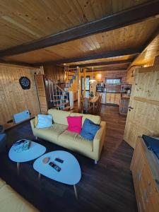 een woonkamer met een bank en twee tafels bij Chata Osmička in Zlaté Hory