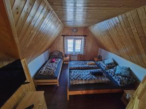 een kamer met twee bedden in een houten hut bij Chata Osmička in Zlaté Hory