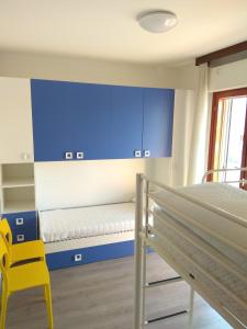 una camera da letto con pareti blu, un letto e una sedia gialla di Meridiana, 2 Bedrooms a Caorle