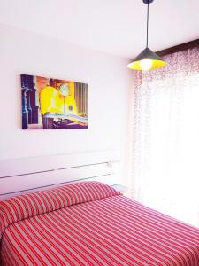 una camera da letto con un letto con copriletto rosso a righe di Meridiana, 2 Bedrooms a Caorle