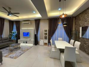 a living room with a dining table and a tv at Aisy Q Homestay Musliim in Kampong Padang Keladi