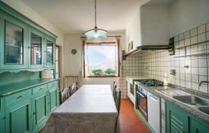 a kitchen with green cabinets and a table with a window at Villa Gioiosa in Caramagna Ligure