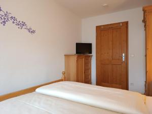 a bedroom with a bed and a wooden door at 2-Raum FeWo Bergtraum - Hallenbad & Sauna in Fischen