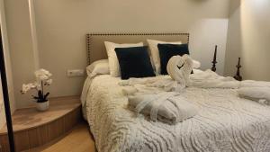 a bedroom with a white bed with towels on it at Leather Loft Rural in Ubrique