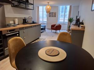 a kitchen with a table and chairs in a kitchen at Joli appartement au coeur de Mâcon in Mâcon