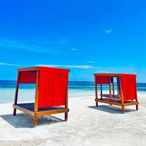 two beach chairs sitting on the sand on the beach at Hospitality Expert Eden 7BR Pools Beach in Montego Bay