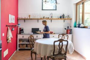 a woman standing in a kitchen with a table at Agriturismo Biomatto in Arona