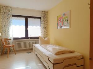 费斯恩4-Raum FeWo Silberdistel - Hallenbad & Sauna的一间带床、窗户和椅子的卧室 更多13张照片