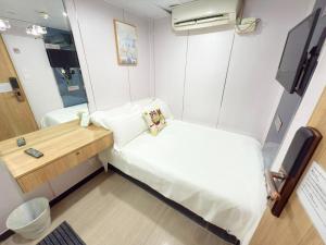 Piccola camera con letto e scrivania. di Apple Hostel 蘋果賓館 a Hong Kong