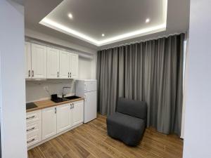 a kitchen with white cabinets and a chair in a room at Villa Scorpio in Qeparo
