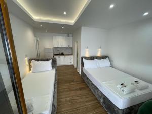 two beds in a small room with a kitchen at Villa Scorpio in Qeparo