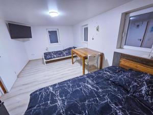 Cette chambre comprend deux lits, un bureau et une table. dans l'établissement Shared house Gebersheim Leonberg, à Leonberg