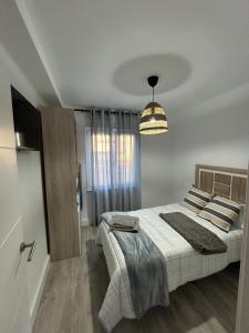a bedroom with a bed and a chandelier at Apartamento de la playa VUT 7012 AS in San Juan de Nieva
