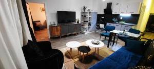 a living room with a blue couch and a table at Villa Erdődy Resort - Apartmán U veveričky in Oravská Lesná