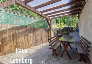 une pergola en bois avec une table de pique-nique et un banc dans l'établissement Shared house Gebersheim Leonberg, à Leonberg