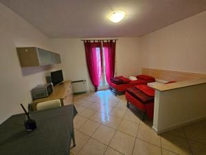 a living room with a red couch and a table at Casa vacanze 7 in Pescincanna +6 photos