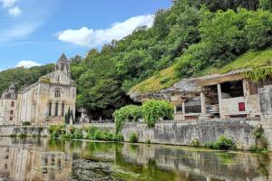 an old building next to a river with a church at Maison de charme à Brantôme en Périgord avec piscine partagée in Brantôme