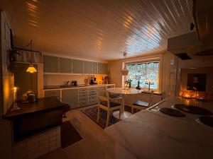 a kitchen with a table and a dining room at Stuga nära Ullared Mitt i Åkulla bokskogar in Rolfstorp