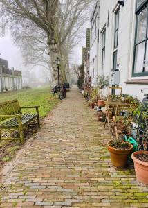 a brick path with benches and tables and a tree at Scheepmakershaven in Schoonhoven