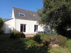 ein weißes Haus mit einer Veranda und einem Garten in der Unterkunft Les Oyats in Les Pieux