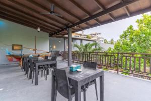 a patio with tables and chairs on a balcony at Sea View Villa Ukulhas in Ukulhas