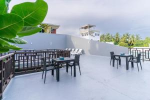 a group of tables and chairs on a balcony at Sea View Villa Ukulhas in Ukulhas