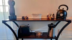a table with a coffee maker and a kettle on it at Meublé de caractère Les arts Danse in Le Puy-en-Velay
