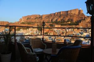 a balcony with chairs and a table and a mountain at Castle View Heritage Haveli in Jodhpur +37 photos