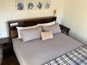a bed with three pillows on it in a room at Akari Bungalows #3 in Long Beach