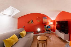a living room with a couch and a red wall at Saint germain sartre apartment in Paris