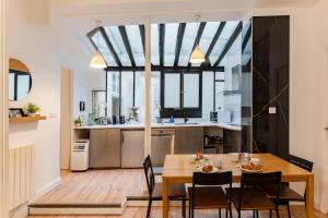 a dining room and kitchen with a table and chairs at Saint germain sartre apartment in Paris