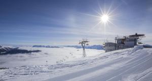 een uitzicht op een met sneeuw bedekte berg met de zon bij Ferienwohnung Thurntaler in Sillian +8 foto's