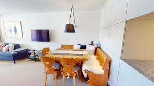 une salle à manger avec une table et des chaises en bois dans l'établissement Au Réduit 403, à Saint-Moritz 1 autre photo