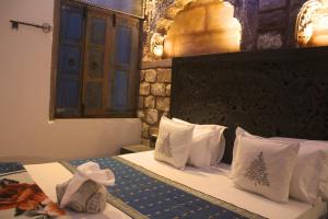 a bedroom with a bed with white pillows at Castle View Heritage Haveli in Jodhpur