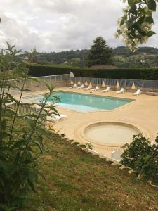 a swimming pool with lounge chairs and a bunch ofitures at Le N5 des Hauts de Sarlat Apt Duplex Clim, Piscine, Parking in Sarlat-la-Canéda