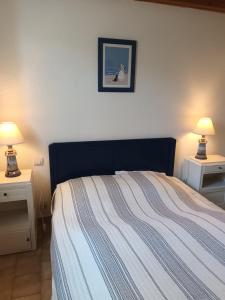 een slaapkamer met een bed en twee nachtkastjes met lampen bij Le clos de la Galiote in Saint-Pierre-dʼOléron +7 foto's