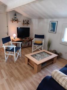een woonkamer met een salontafel en een tv bij Le clos de la Galiote in Saint-Pierre-dʼOléron