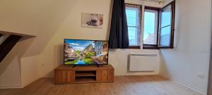 a living room with a flat screen tv on a wooden table at Le Coin Zen - Parking, Borne VE et Fibre in Bergheim