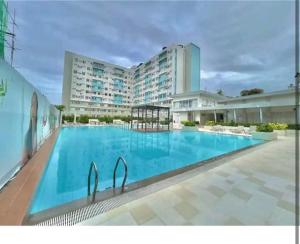 a large swimming pool in front of a large building at CoNDOTEL DC in Dumaguete