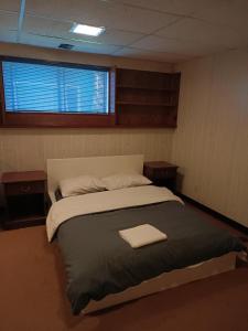 a bedroom with a large bed with two night stands at Burnaby house by New Westminster in Burnaby