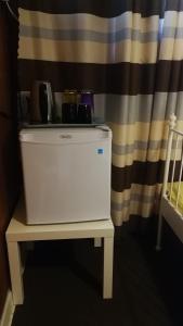 a white freezer sitting on a table in front of a curtain at Burnaby house by New Westminster in Burnaby